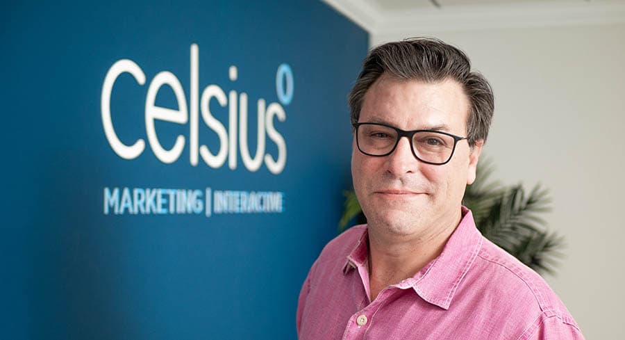 Photo of CEO and founder JP Smith, standing in front of the Celsius logo in the front lobby.